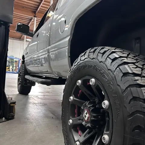Dodge Ram 2500 off road diesel pickup on the lift with a fresh BFGoodrich all terrain tire at Rapid Diesel Repair in Ontario, CA